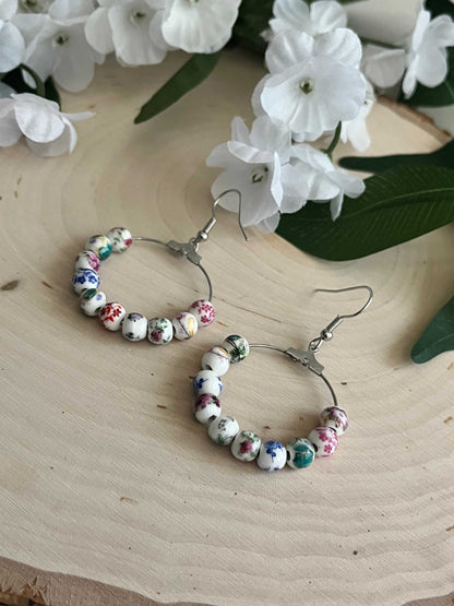 Floral hoop earrings – multicolored beaded silver jewelry with a floral design.
