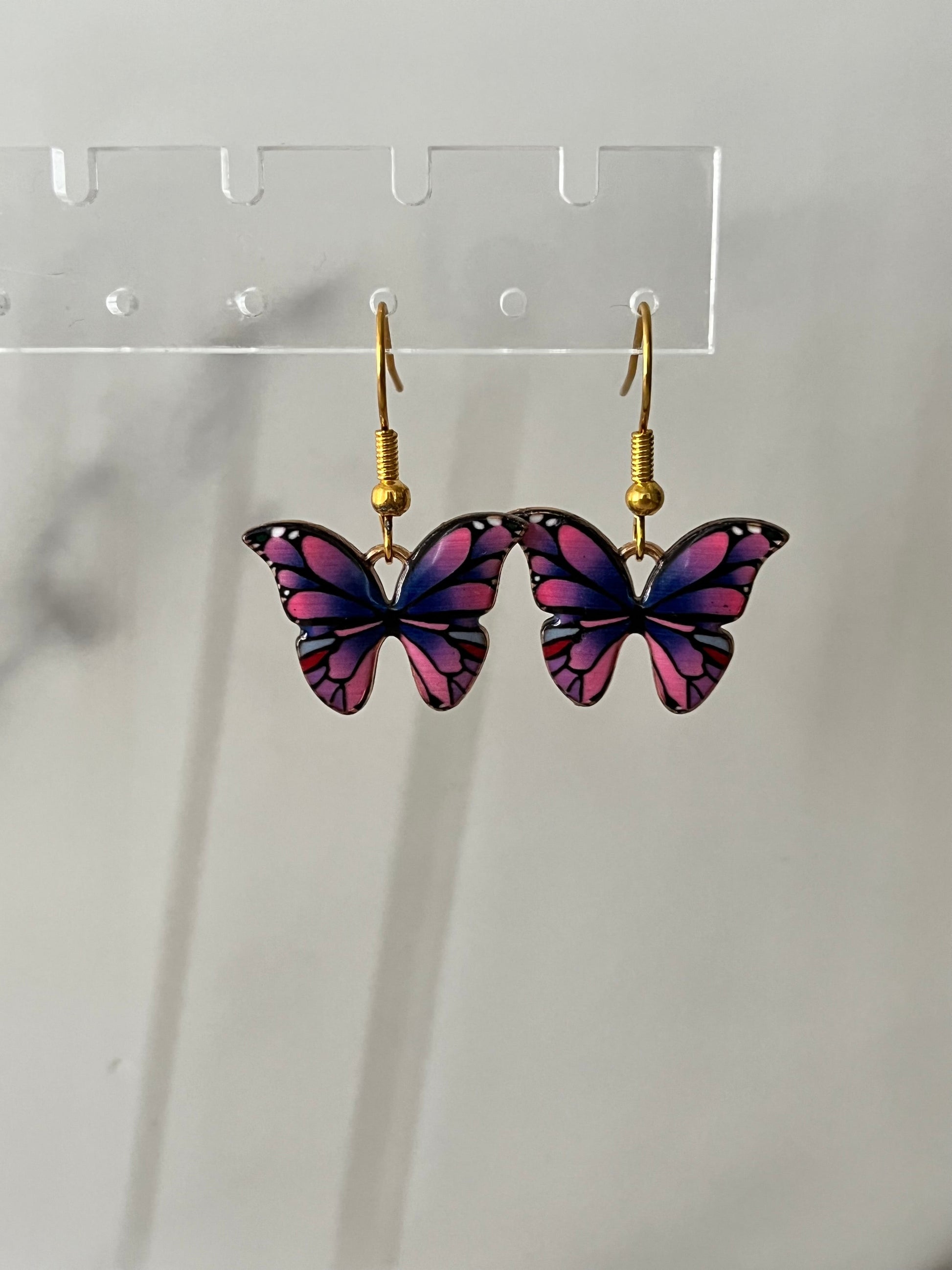 Gold earrings with pink or purple butterfly design

