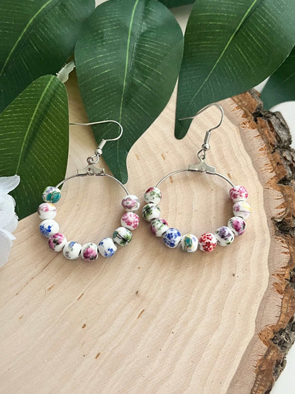 Floral hoop earrings – multicolored beaded silver jewelry with a floral design.
