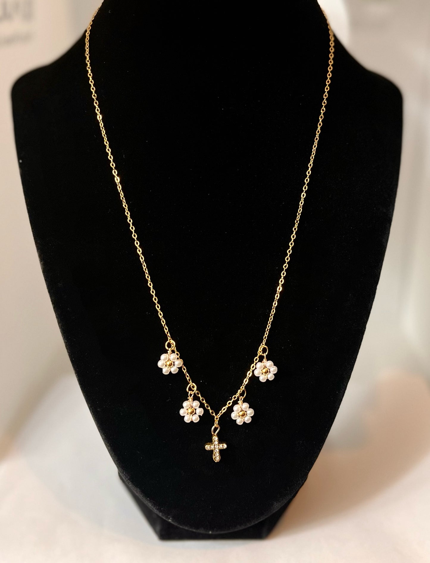 Gold Necklace with 16K gold pendant featuring daisies and a cross.


