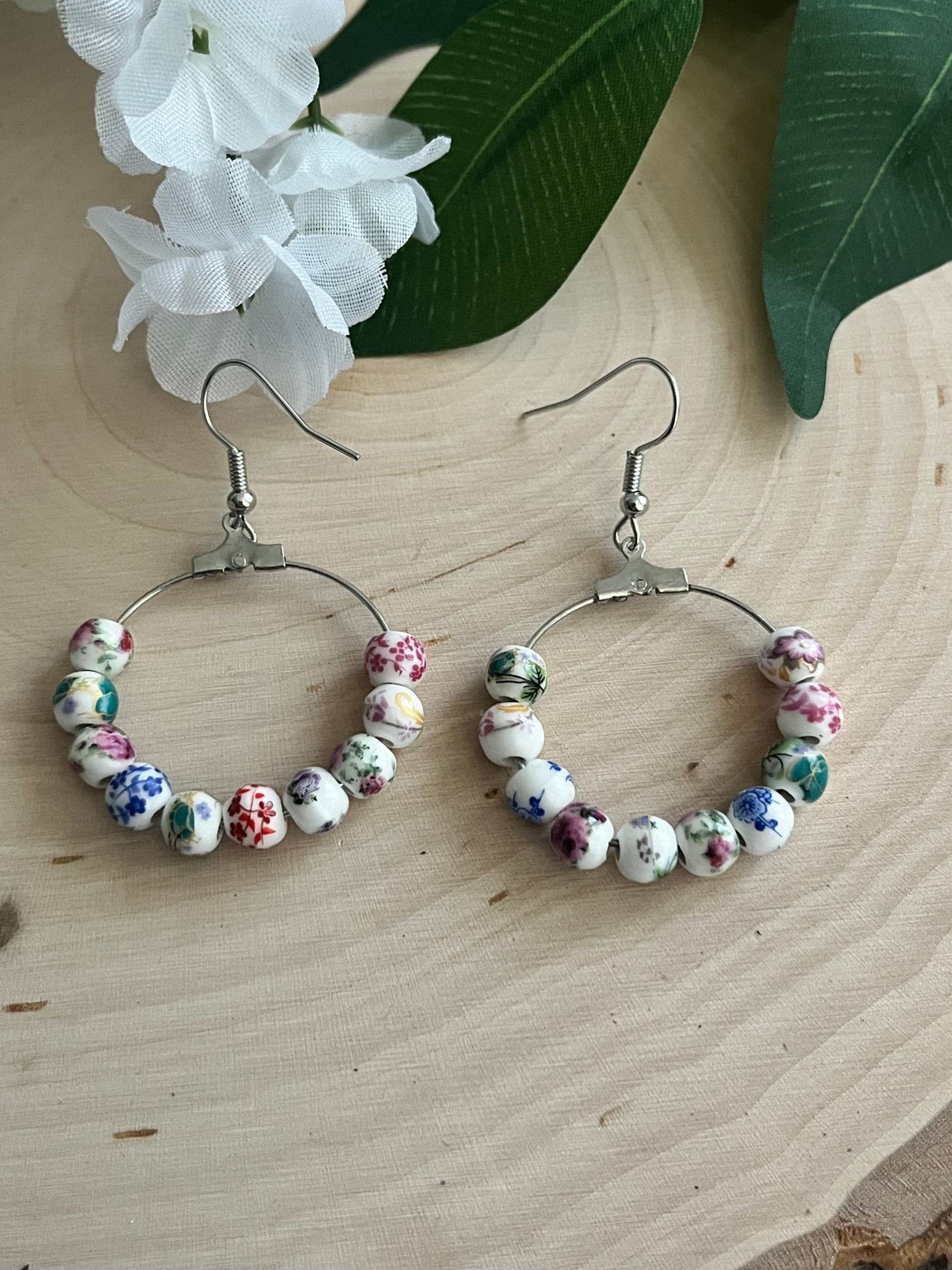 Floral hoop earrings – multicolored beaded silver jewelry with a floral design.
