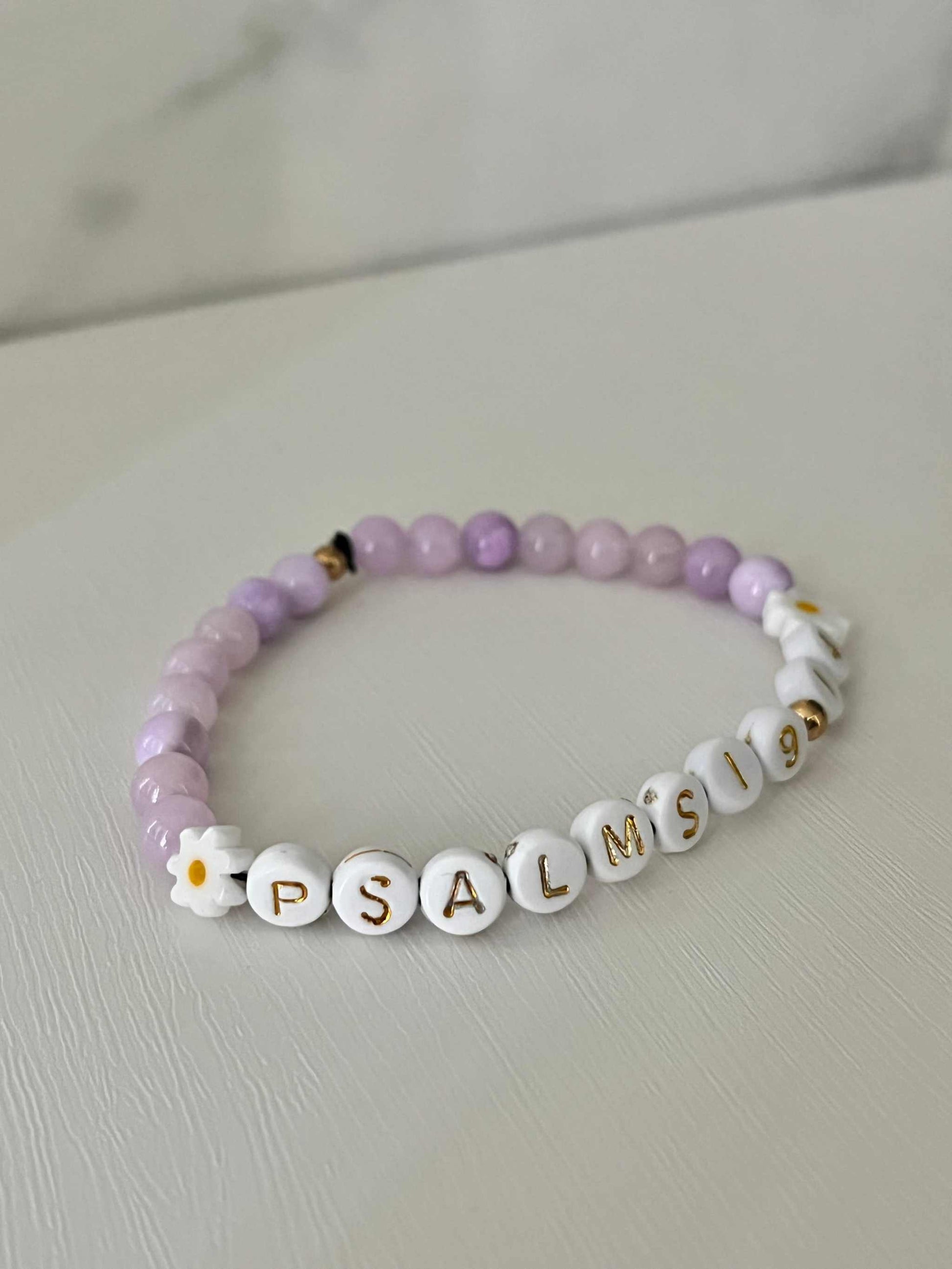 Lavender Daisy Rhodonite Bracelet showcasing white daisies and lavender rhodonite beads, ideal for expressing faith and style.