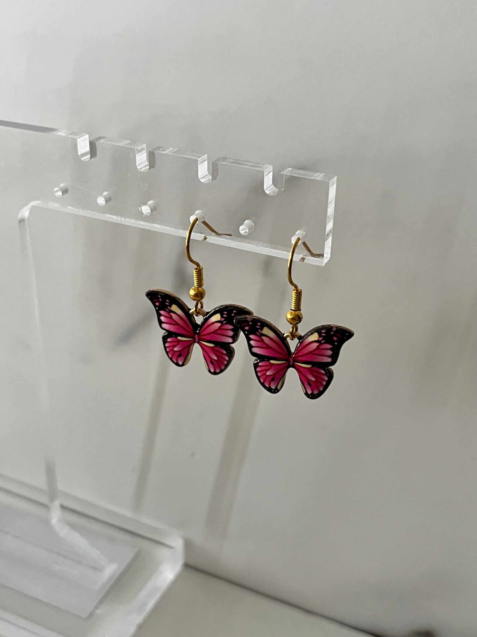 Gold earrings with pink or purple butterfly design

