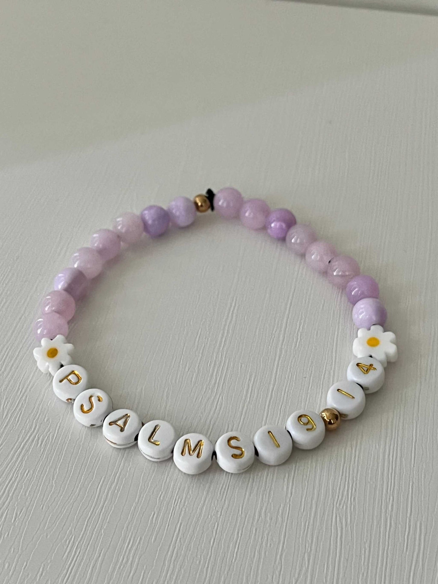 Lavender Daisy Rhodonite Bracelet showcasing white daisies and lavender rhodonite beads, ideal for expressing faith and style.