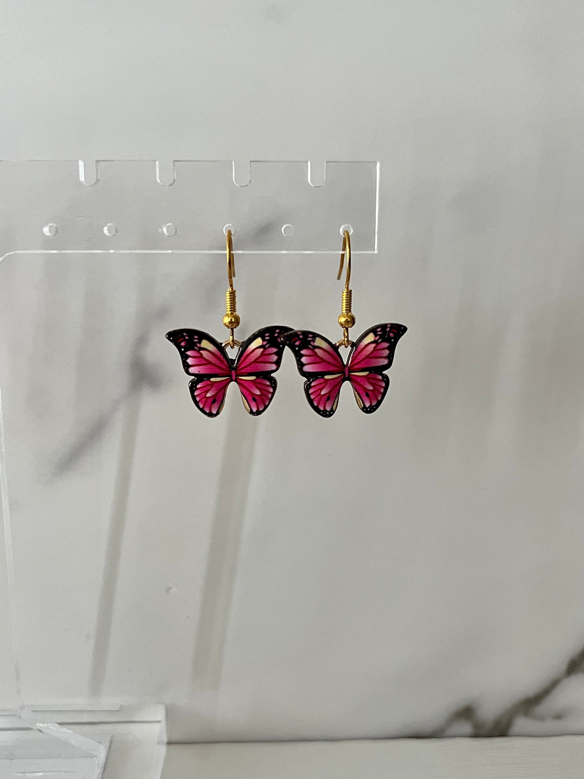 Gold earrings with pink or purple butterfly design

