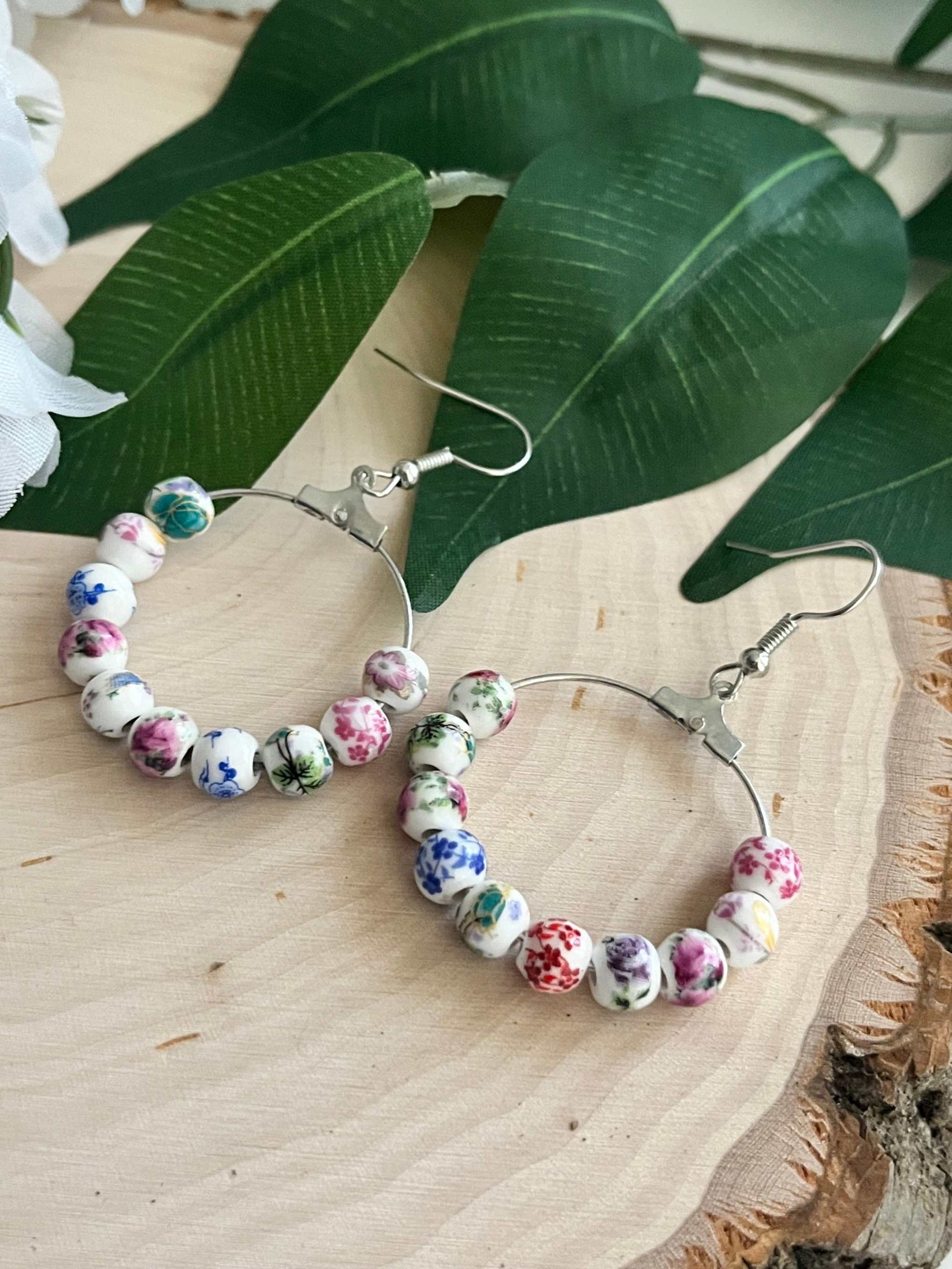 Floral hoop earrings – multicolored beaded silver jewelry with a floral design.
