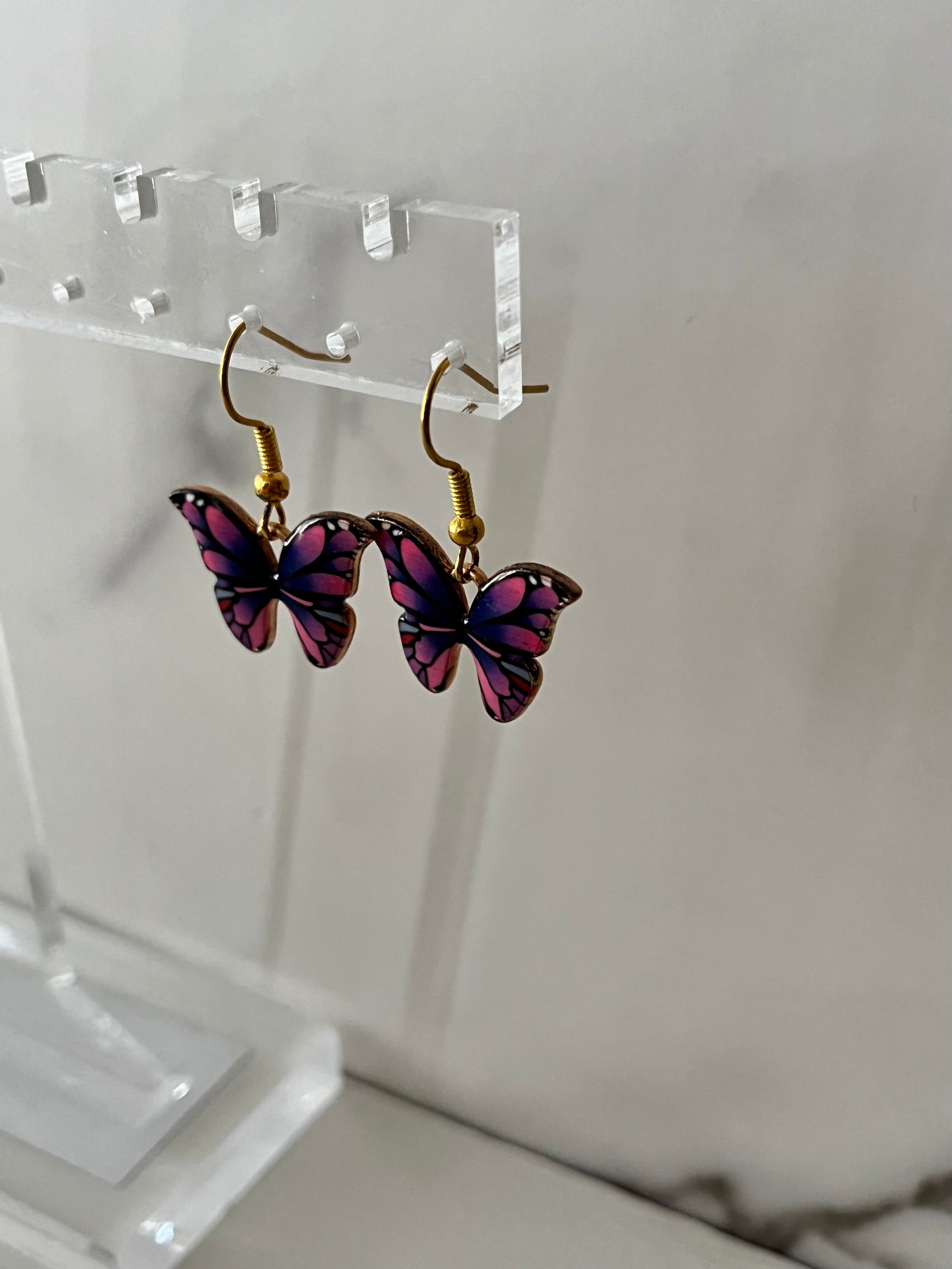 Gold earrings with pink or purple butterfly design

