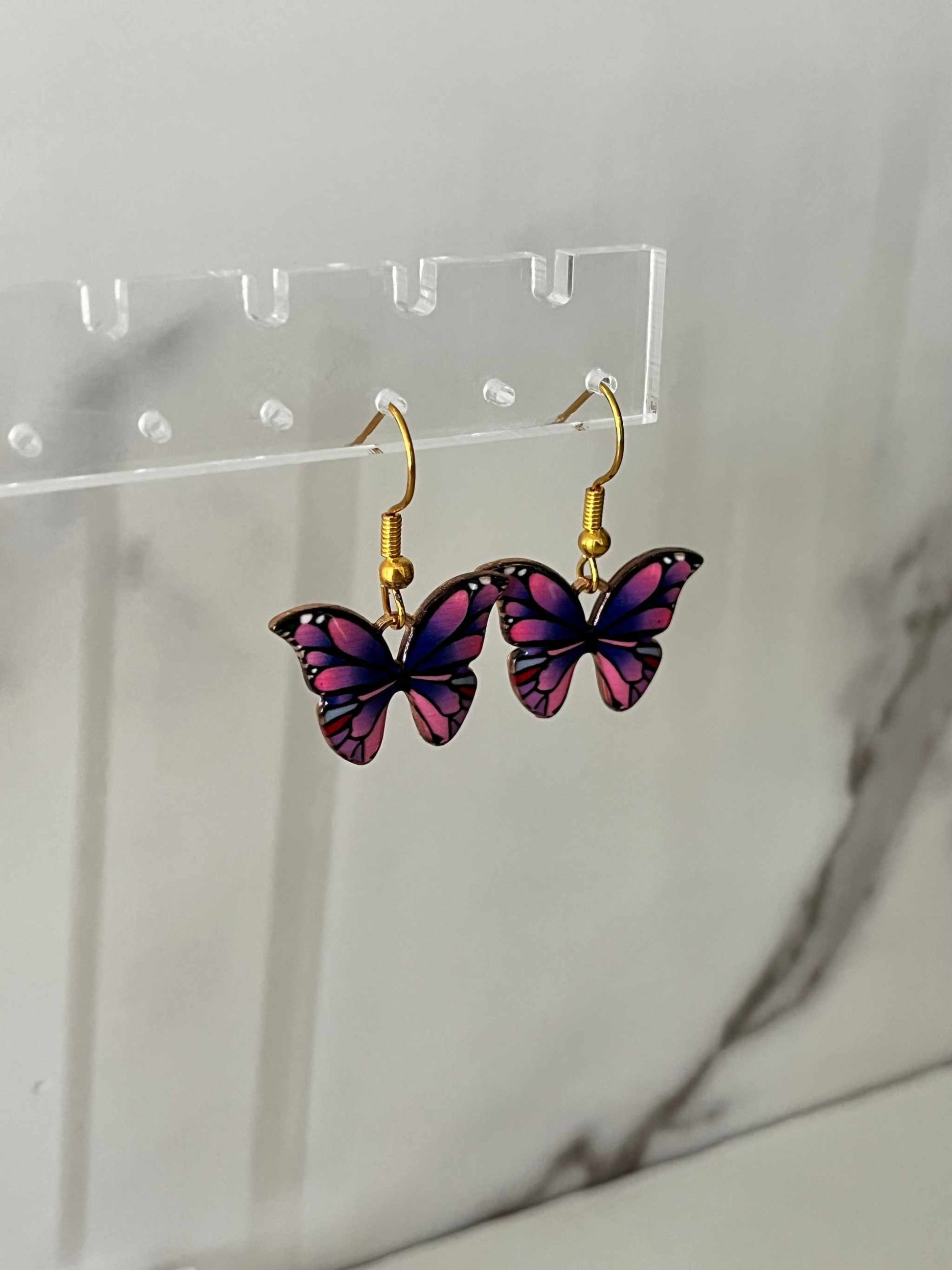 Gold earrings with pink or purple butterfly design

